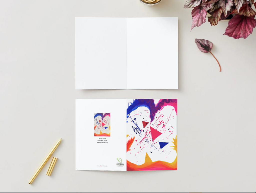 A6 greeting card with abstract colorful triangles and paint splatters, featuring a premium satin finish and white interior.