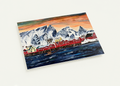 A6 greeting card featuring a hand-painted Norwegian fishing village with red houses, snowy mountains, and a vibrant sunset.