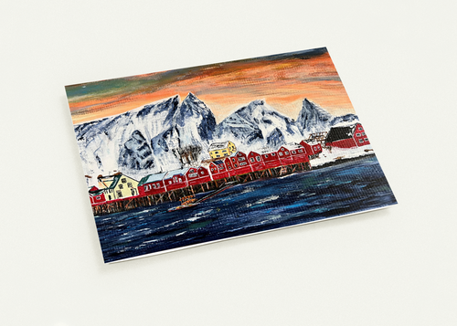 A6 greeting card featuring a hand-painted Norwegian fishing village with red houses, snowy mountains, and a vibrant sunset.