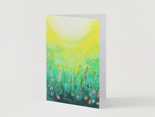 A6 folded greeting card featuring a vibrant hand-painted wildflower meadow in green and yellow with a satin finish.