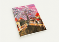 A6 greeting card featuring a textured, hand-painted scene of Hanoi’s old streets with vibrant pink trees and red-roofed houses.