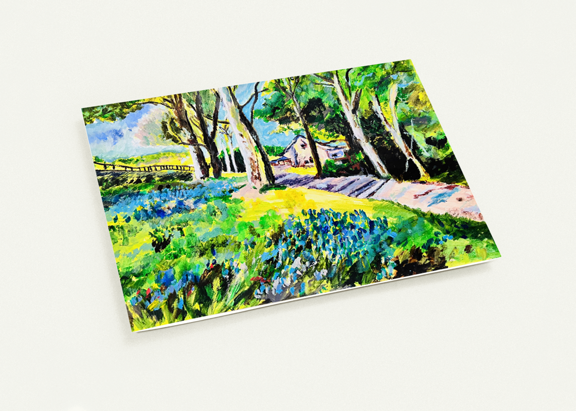 A6 greeting card featuring a hand-painted summer house landscape with vibrant green trees and blue flowers on premium cardstock.