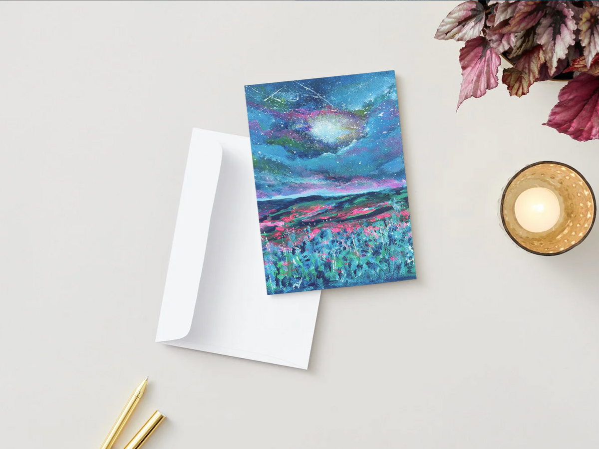 A6 greeting card with a hand-painted night sky design, featuring vibrant blue and pink colors, displayed with a white envelope.