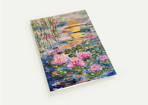 Greeting card front with colorful water lilies over a pond scene, laid flat on a background