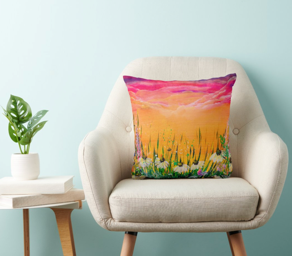 Decorative polyester cushion with sunset field landscape print, on a cream upholstered chair
