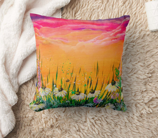 Decorative polyester cushion with sunset field landscape print, on a textured beige throw blanket