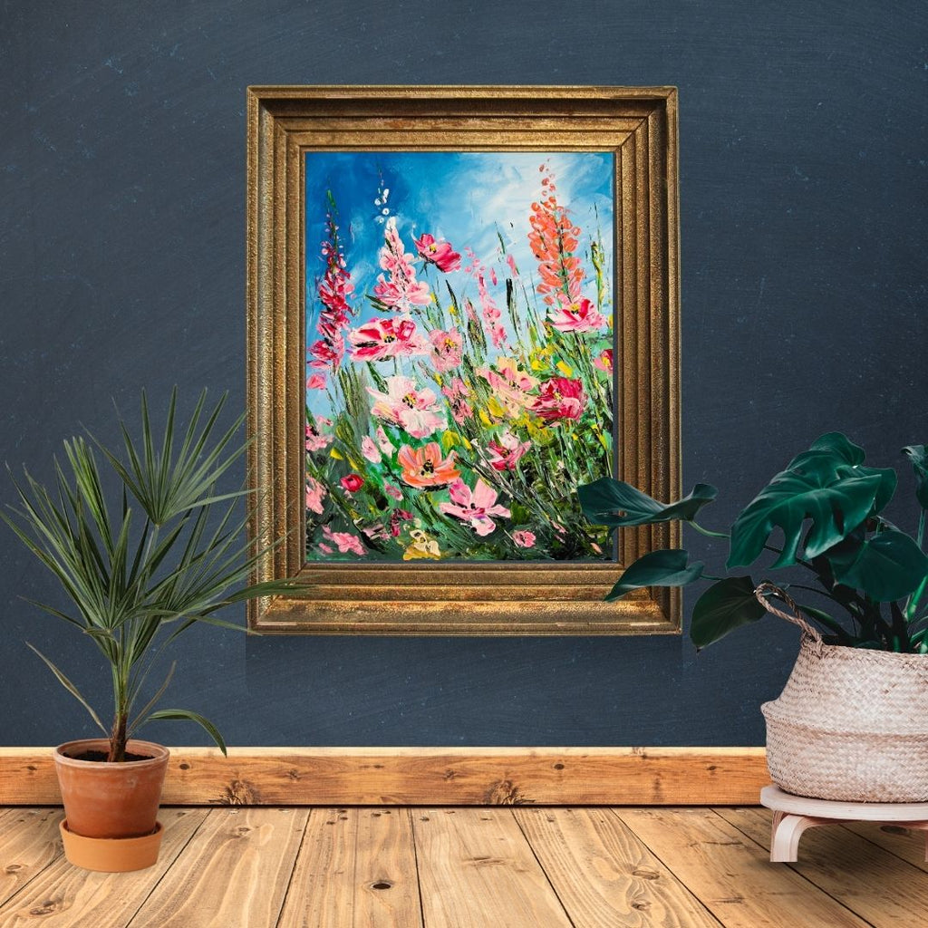 Gold-framed floral art print with pink and orange blooms and green foliage on blue sky