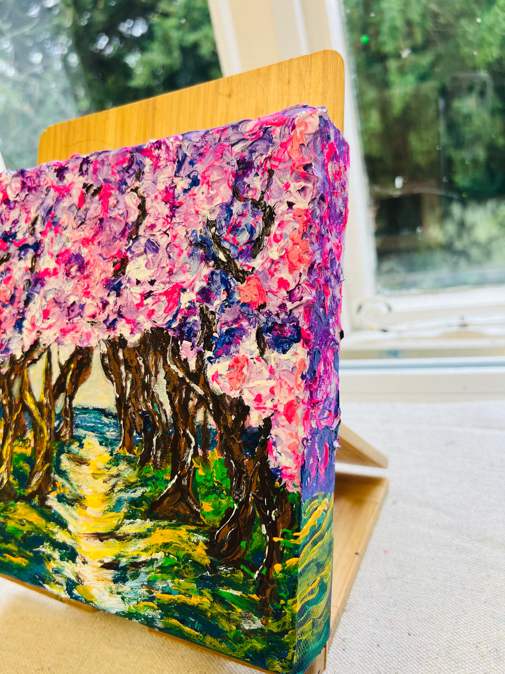 Framed 3D texture artwork in side view on wooden panel, colorful forest scene
