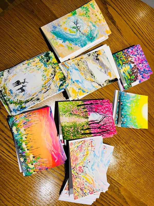 Collection of A6 folded greeting cards featuring vibrant, colorful floral and nature-inspired artwork on premium satin paper.