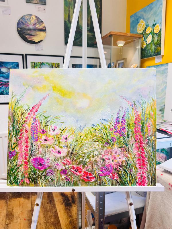 Framed floral wall art with colorful wildflowers and tall grass on an easel