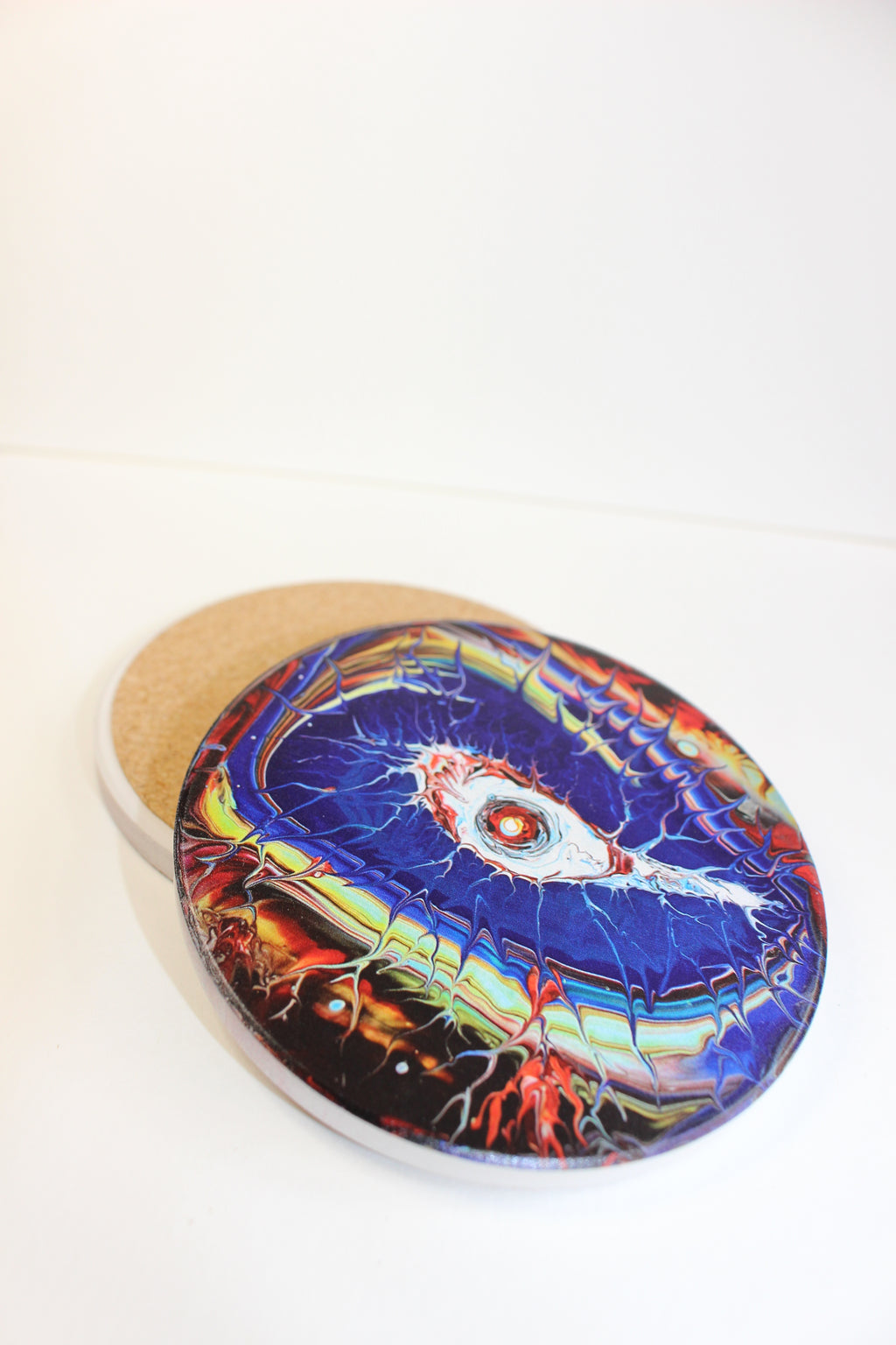 Round ceramic coaster with tan cork base and glossy blue eye design