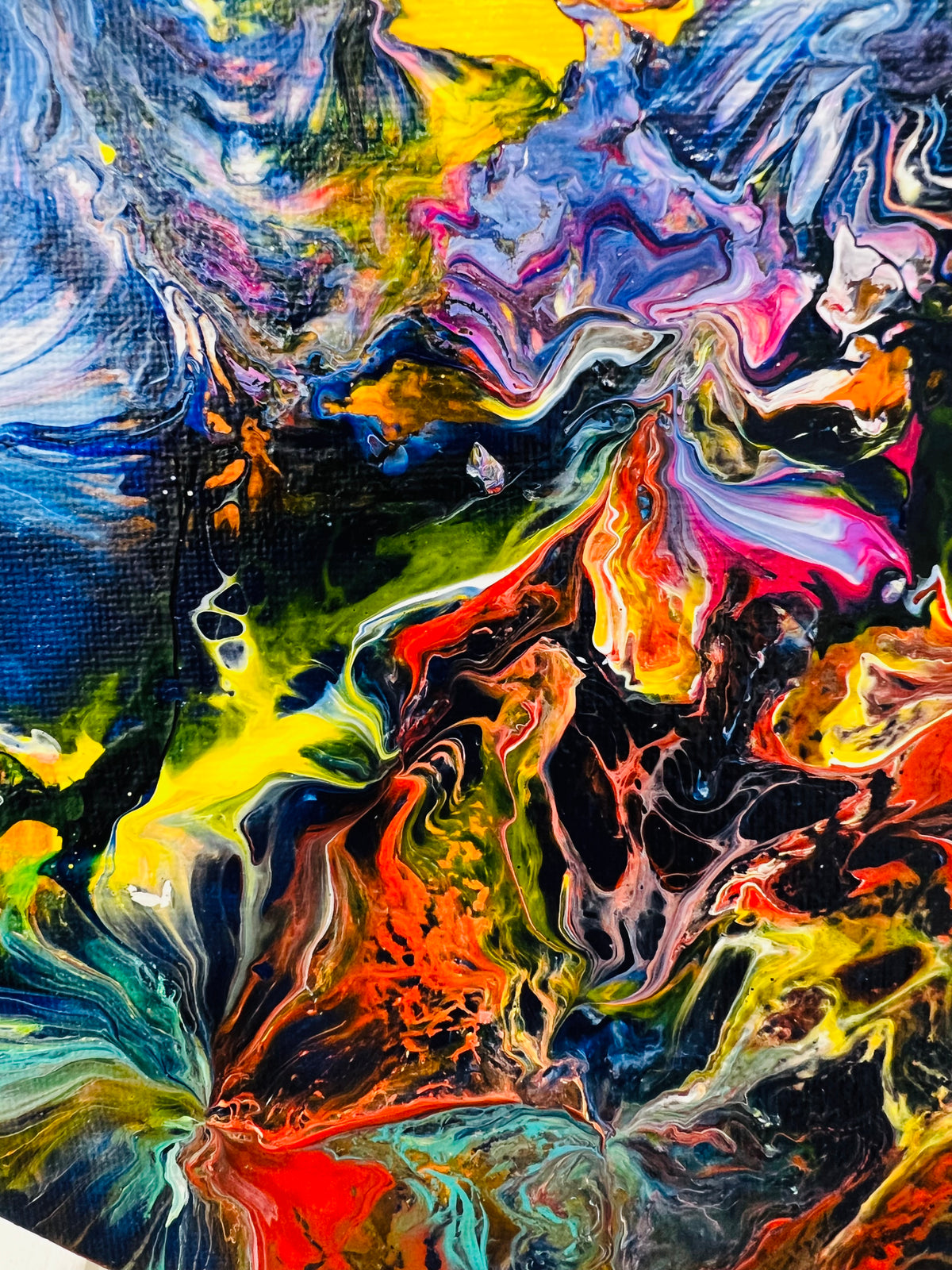 Close-up abstract painting with vivid blue, orange, pink, and green paint swirls