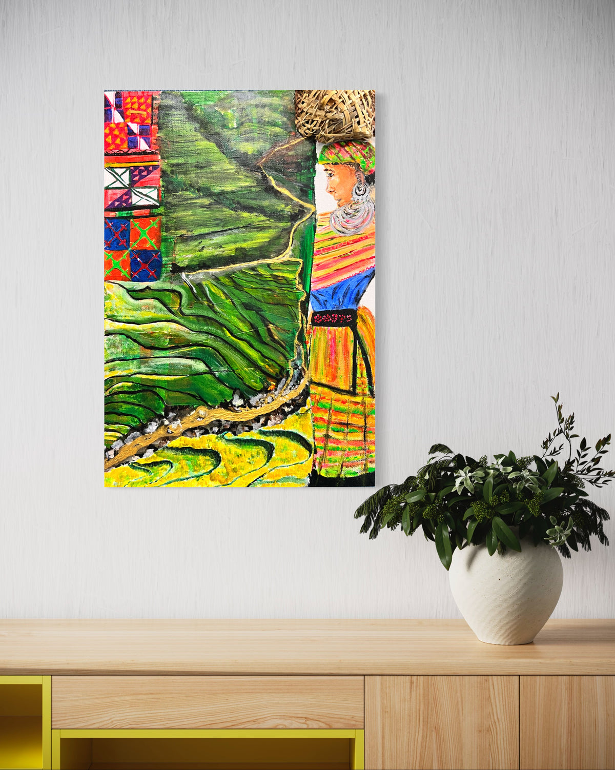 Framed wall art showing green rice terraces with a colorful robed woman portrait.