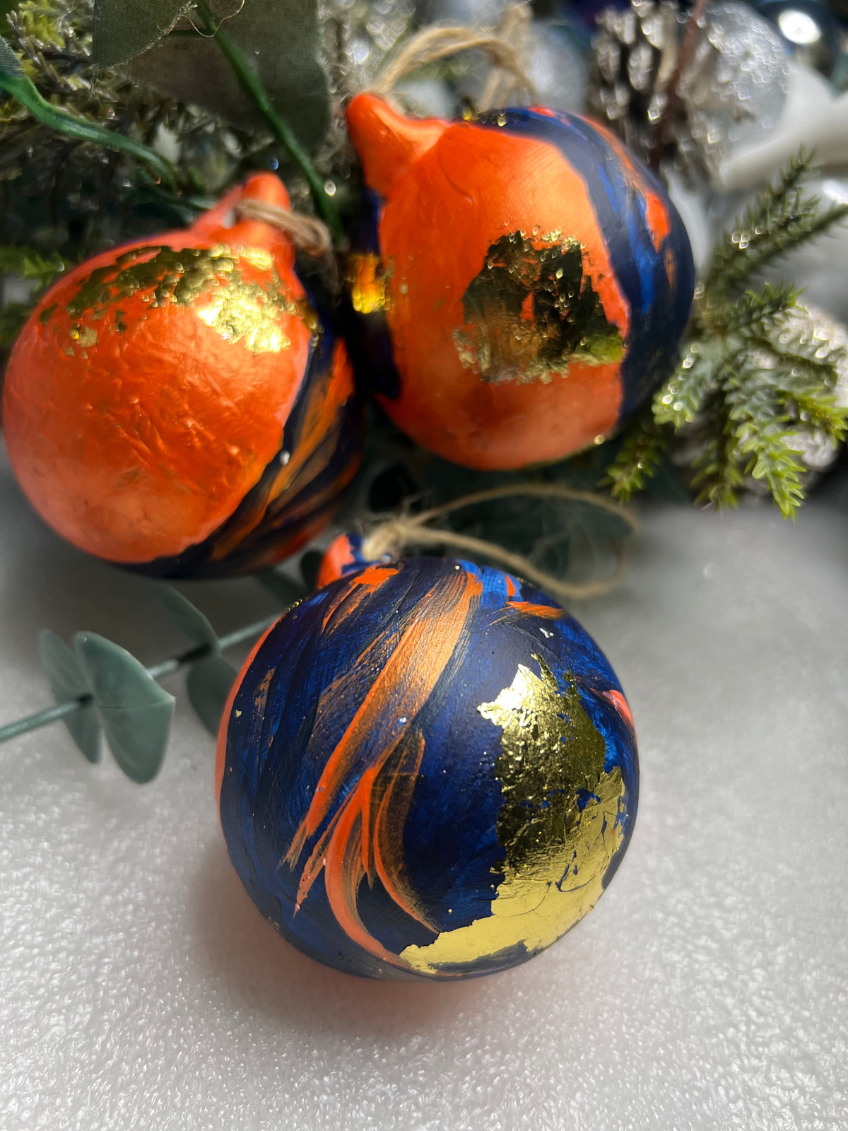 Hand-painted ceramic Christmas bauble, orange and blue with gold leaf accents