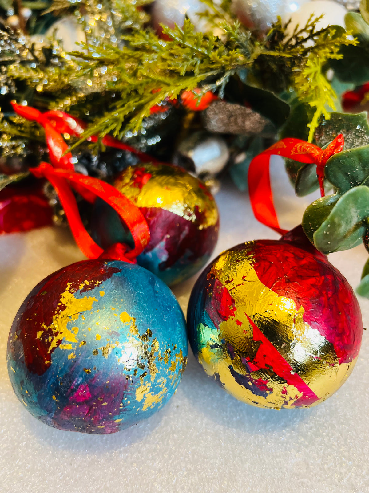 Hand-painted ceramic Christmas baubles with red ribbon bows, red and blue with gold