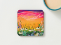 Glossy 9.5cm hardboard coaster featuring a vibrant acrylic painting of a colourful flower field at sunset.
