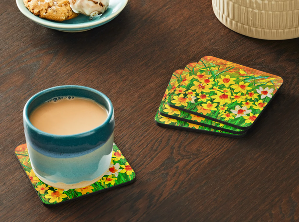 Square 9.5cm hardboard coaster set featuring vibrant yellow daffodil texture art with a glossy finish on a wooden table.
