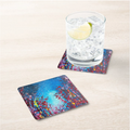 Square dark blue abstract art coaster with multi-color paint splashes under a glass
