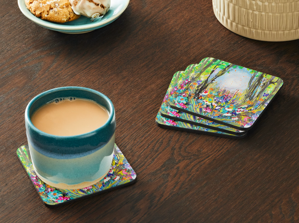 Square 9.5cm hardboard coaster with a vibrant yellow and green wildflower painting, featuring a glossy finish and cork back.