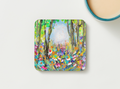 Square hardboard coaster with vibrant wildflower forest painting and rounded corners.