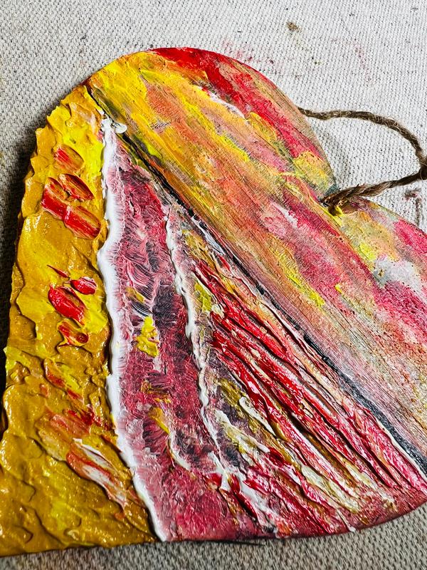 Textured heart decoration with jute hanger, split yellow and red/pink abstract brushstrokes.