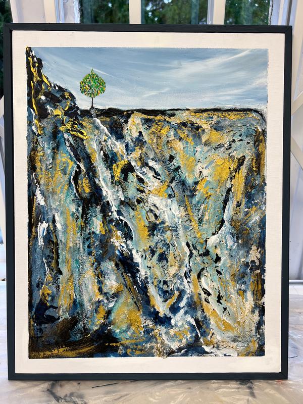 Framed textured abstract wall art with blue and yellow streaks and a small green tree
