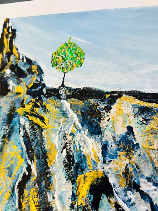 Textured abstract wall art close-up with green tree and blue-yellow brush textures