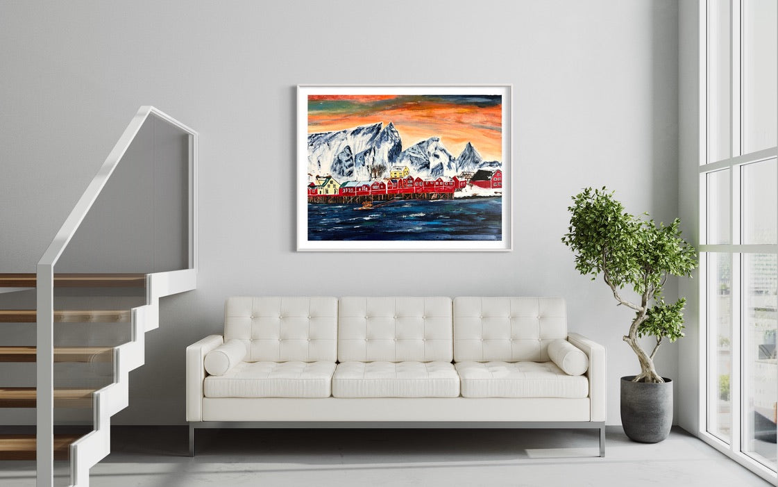 Framed landscape wall art showing snowy mountains and red waterfront houses under orange sky