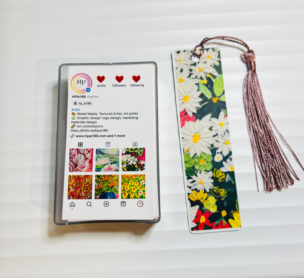 Metal bookmark with white daisy artwork and rose-pink tassel.