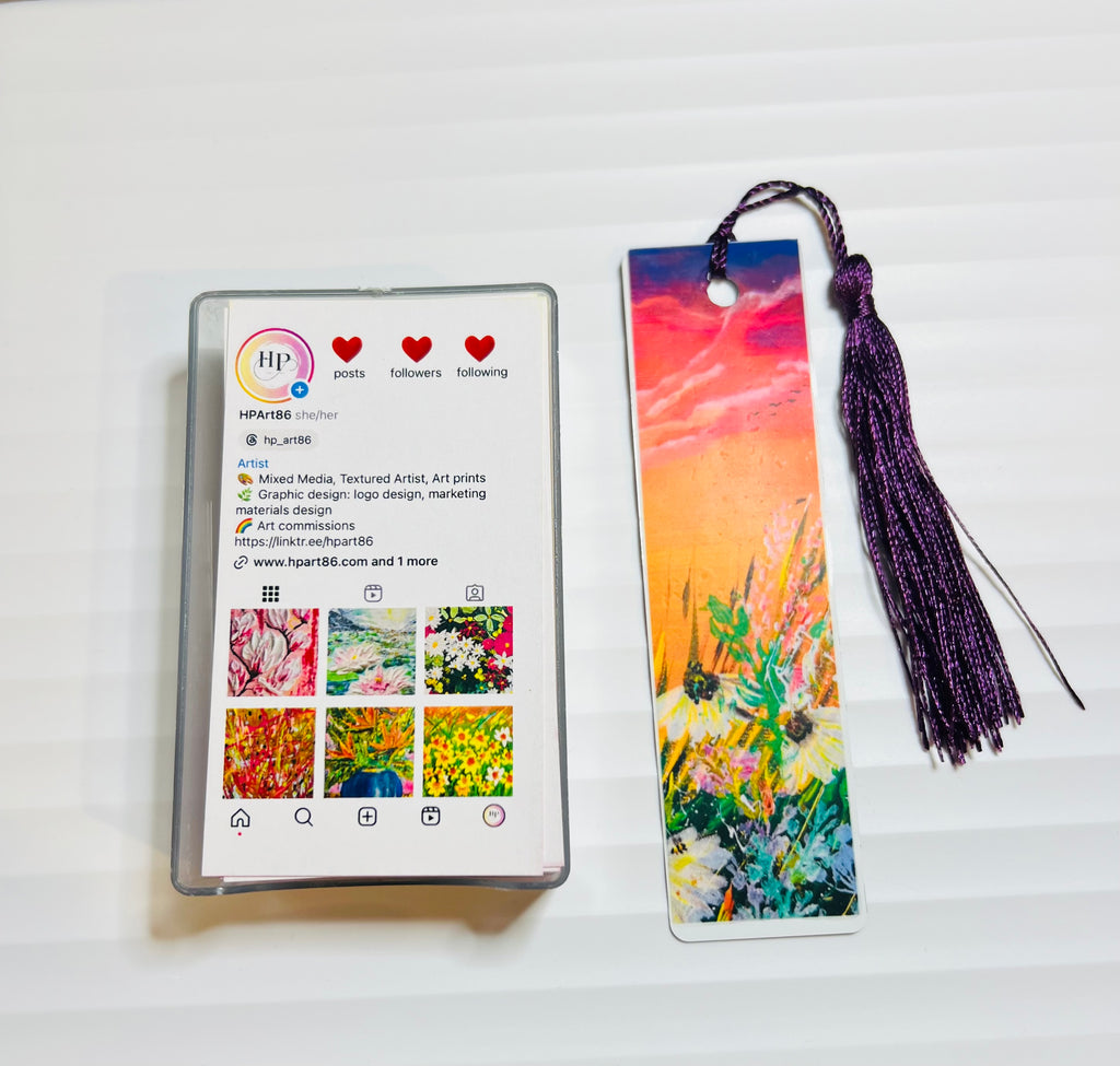 Metal bookmark with orange sunset artwork and purple tassel.
