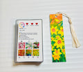 Metal bookmark with bright yellow flower artwork and gold tassel.