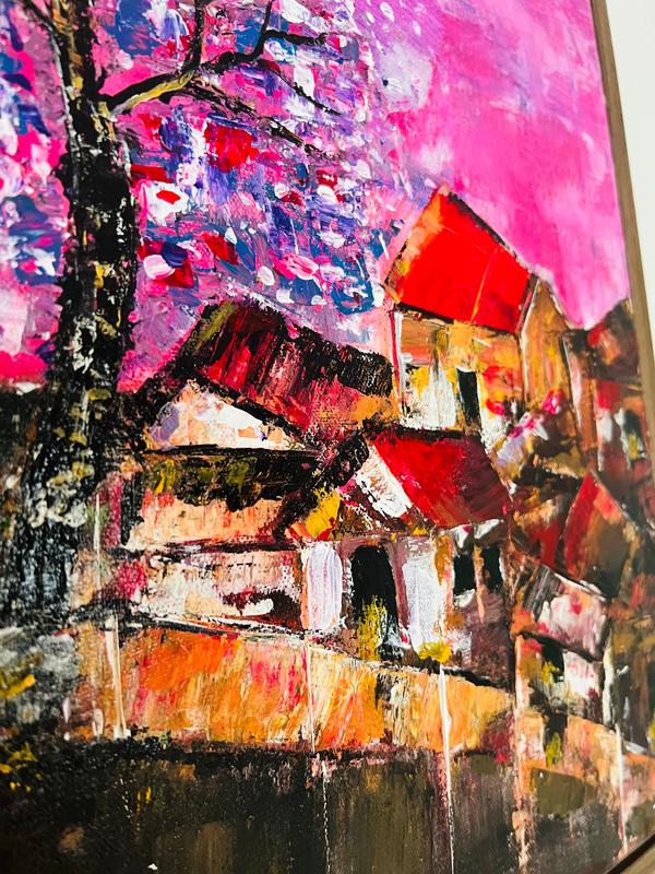Close-up of textured cityscape painting with orange house roofs, dark bridge, and bright pink paint.