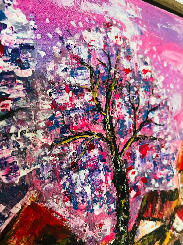 Close-up view of textured artwork with flowering tree branches against vivid pink and blue brushwork.