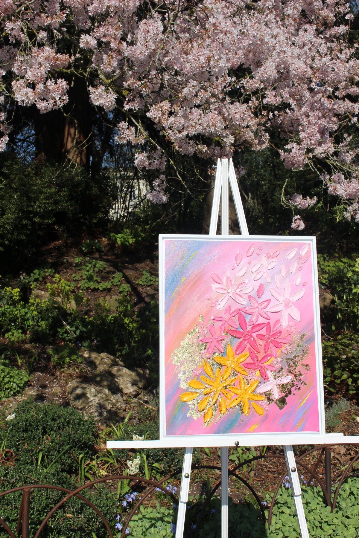 Framed floral wall art with pink and yellow jeweled flowers on pastel canvas, on easel
