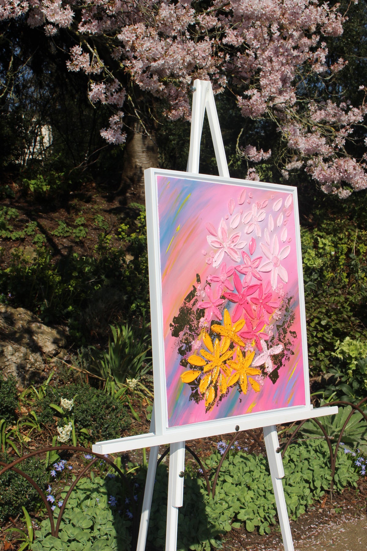Framed floral wall art with pink and yellow jeweled flowers, displayed on a white easel