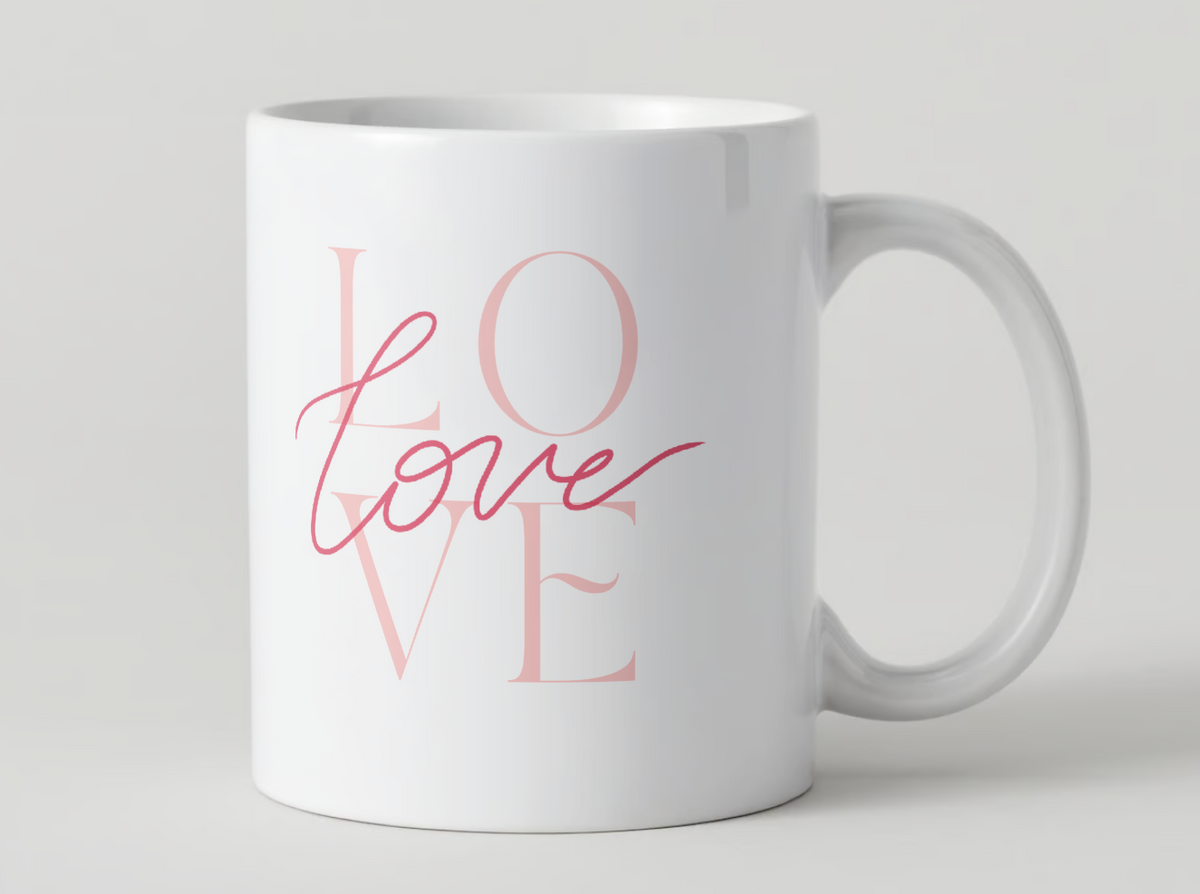 White ceramic mug with rose-pink “LOVE” lettering on the front and handle