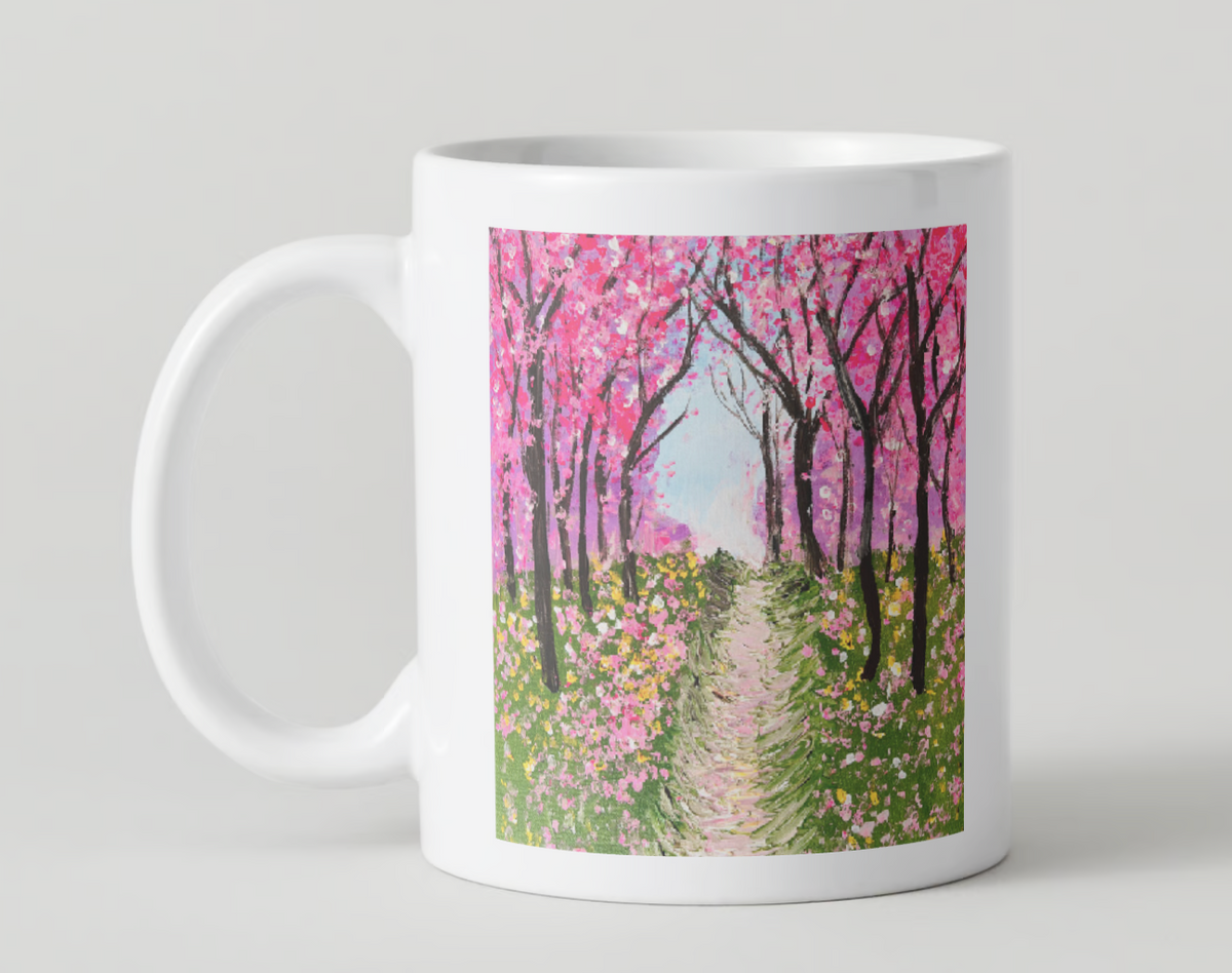 White 11oz ceramic mug with pink cherry blossom tree path print and curved handle