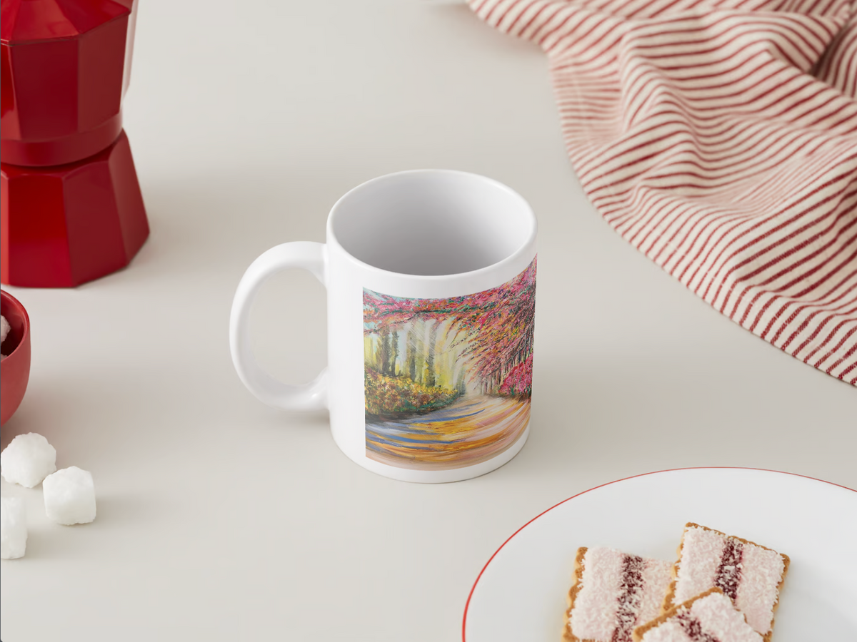 White ceramic mug with colorful landscape design on the front, angled view