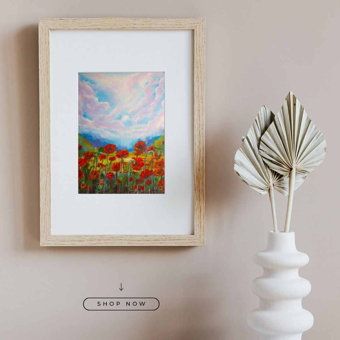 Framed wildflower artwork with red flowers and blue sky, wood-look frame and white mat
