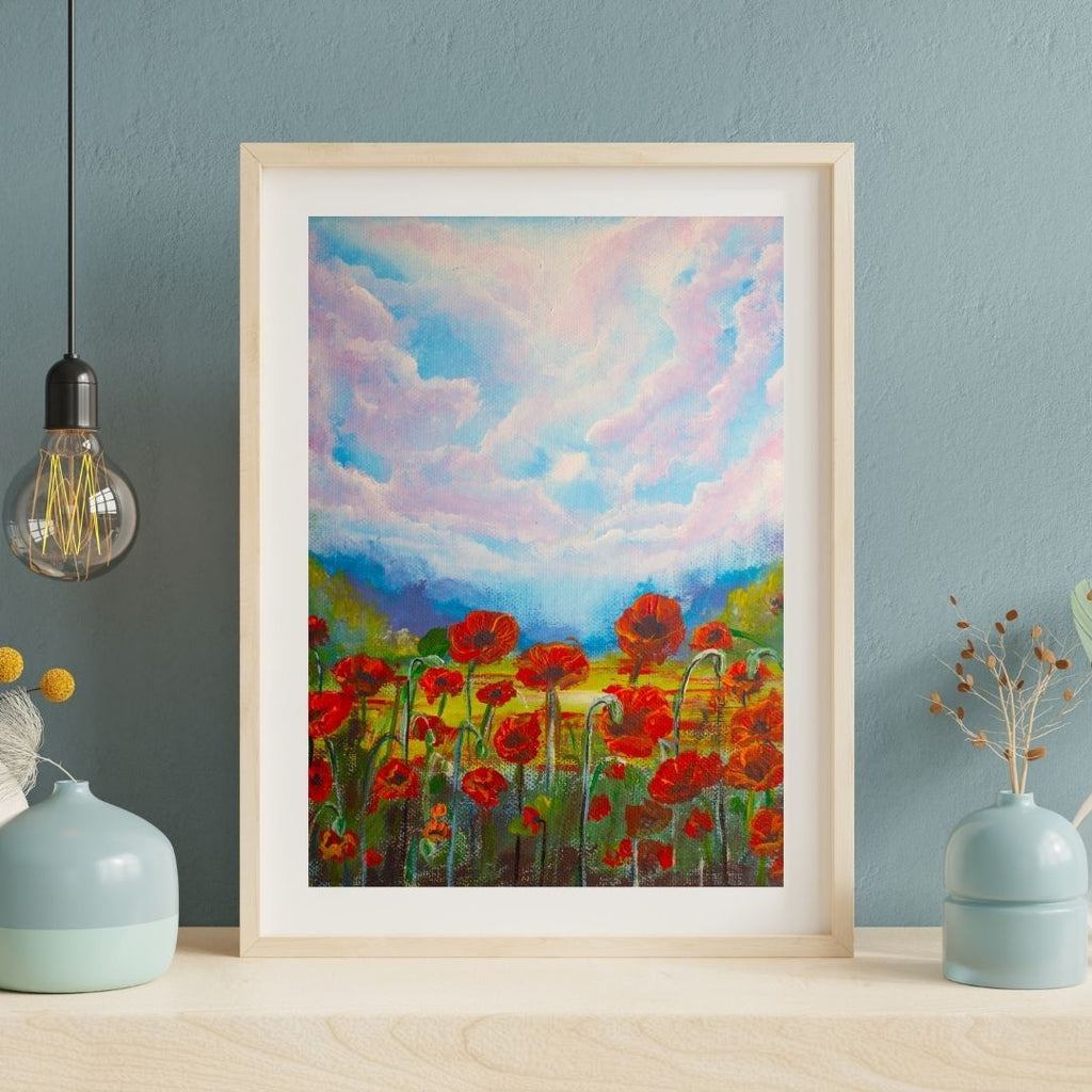 Framed wildflower artwork with red poppies and colorful sky, pale wood frame