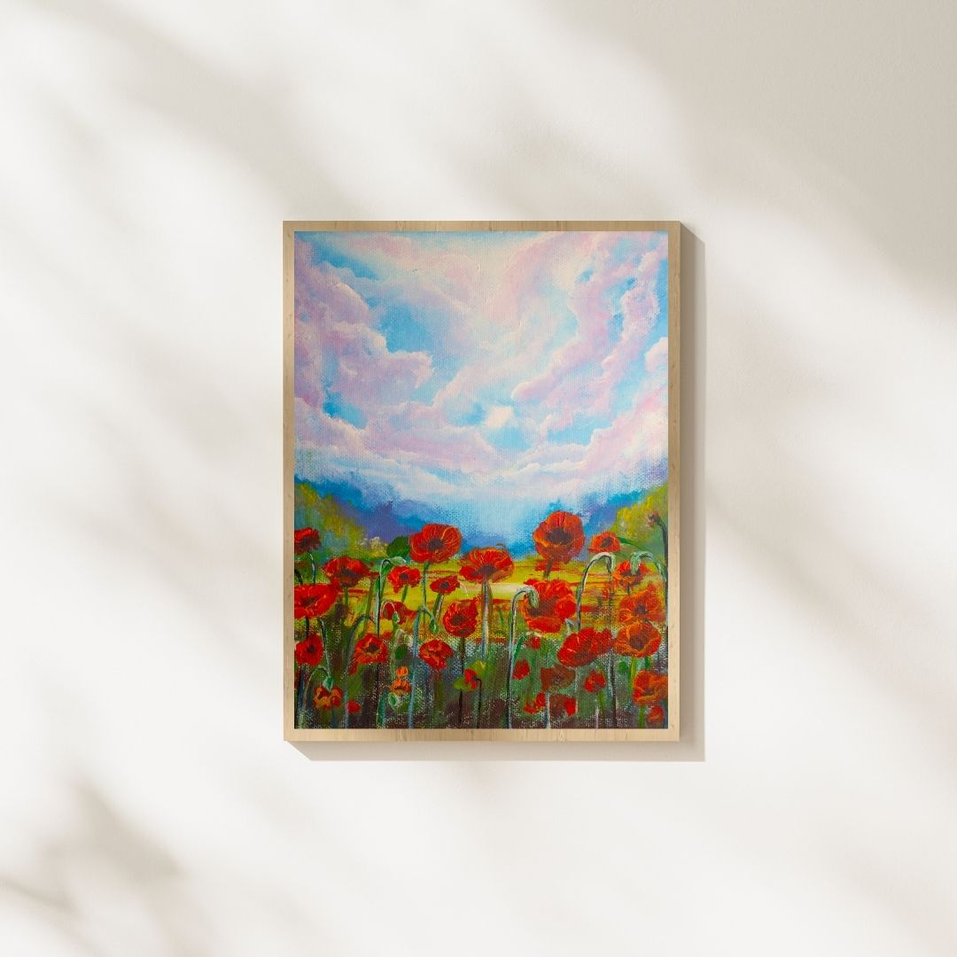Framed wildflower print with red flowers and blue-pink clouds, light wood frame