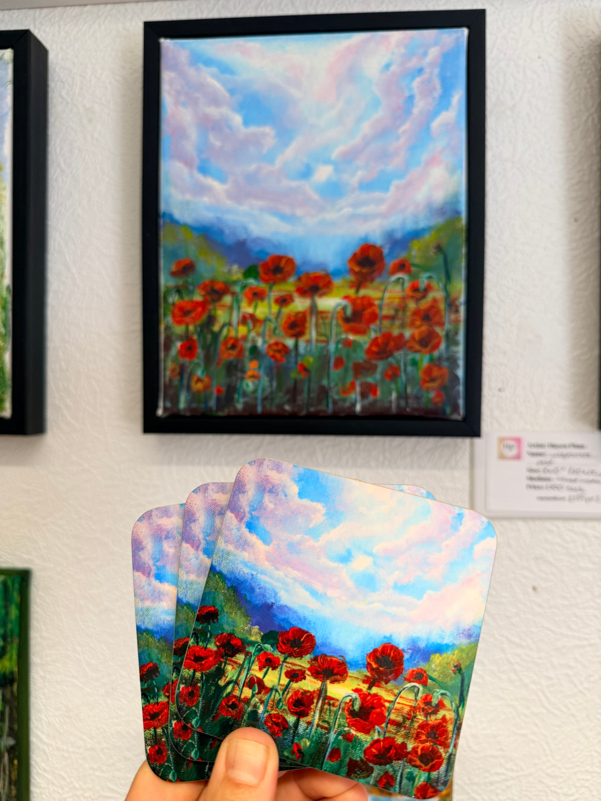 Floral landscape art coaster with red poppies and blue sky, framed look