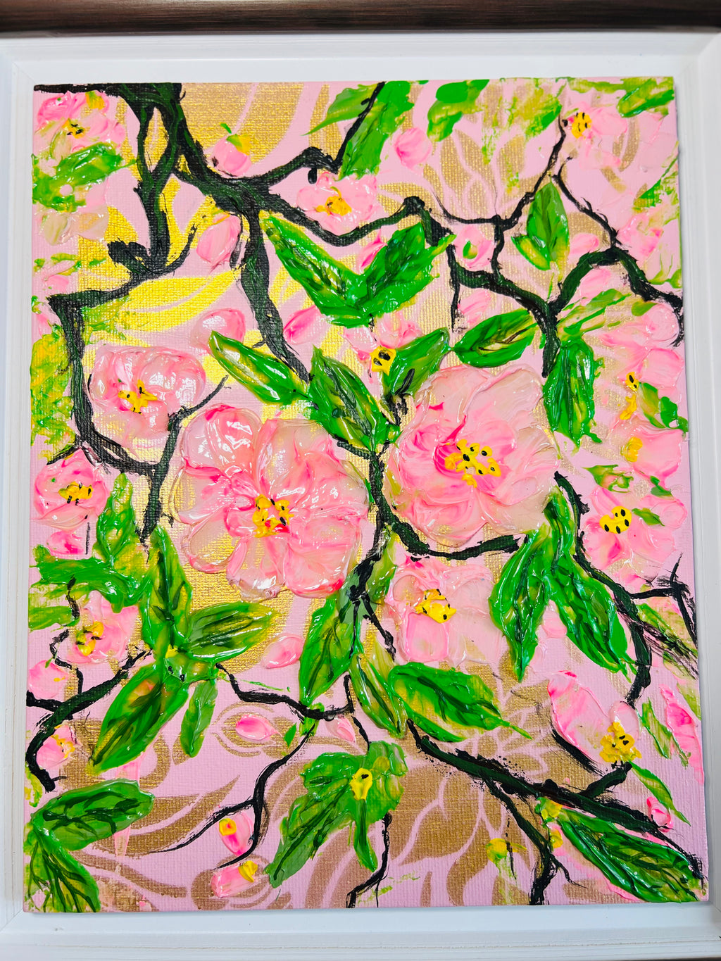 Close-up of framed cherry blossom painting with green leaves and pink petals