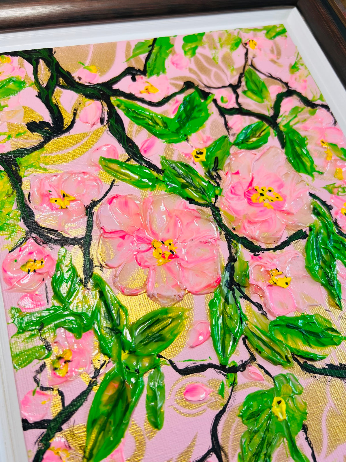 Tight close-up of framed cherry blossom painting with detailed pink blooms