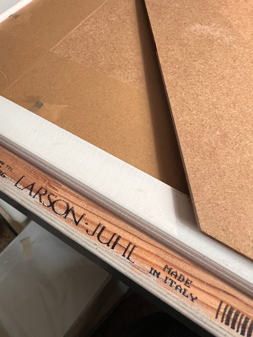 Wood frame artwork back panel with printed text on cardboard backing