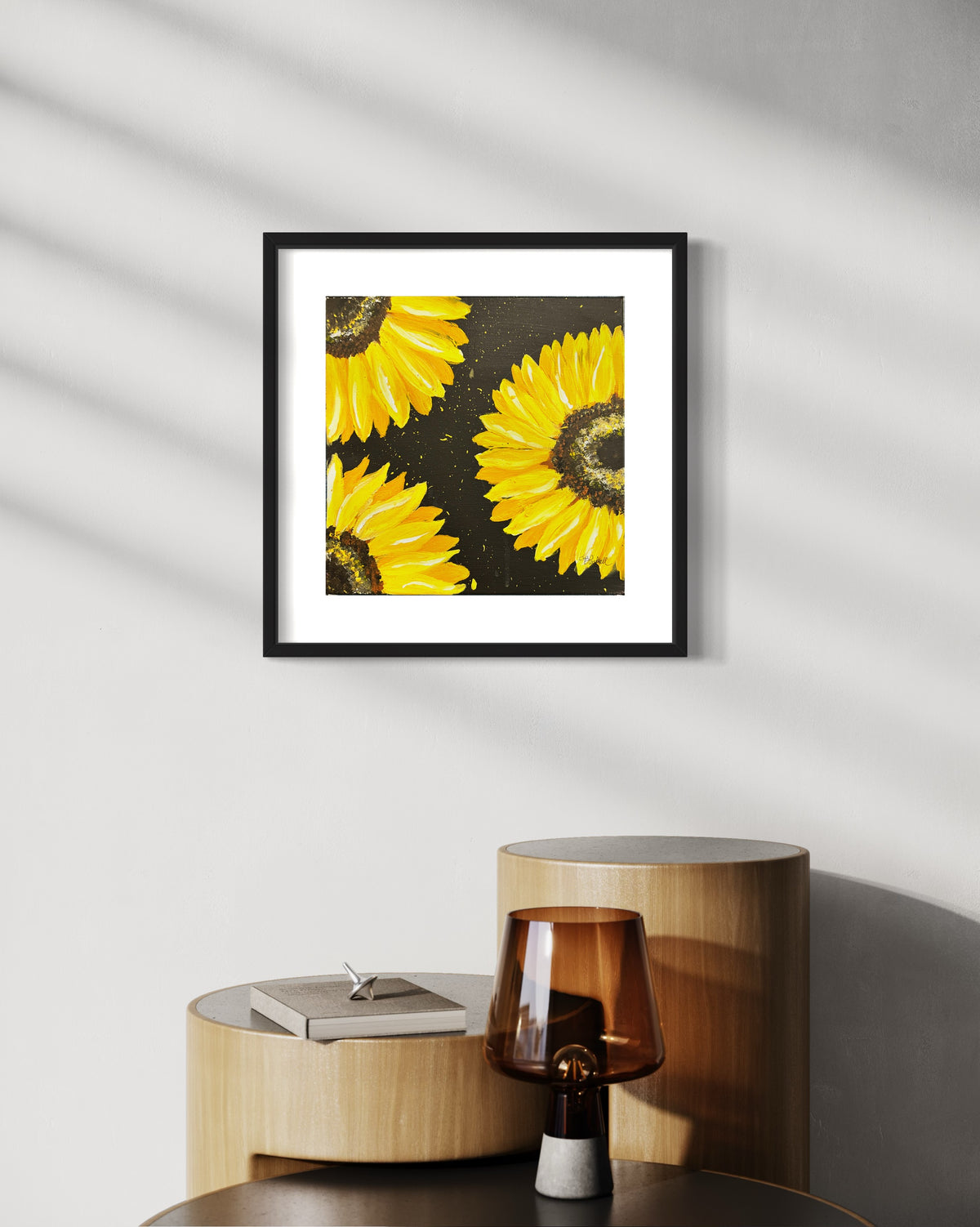 Black-framed sunflower wall art with bright yellow petals on dark textured background.