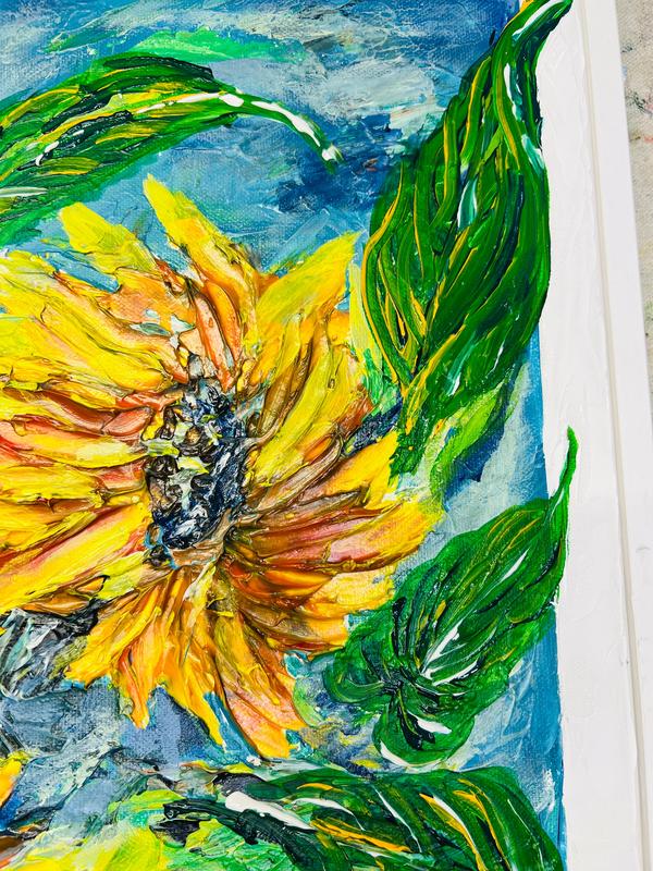 Framed sunflower painting corner view with yellow bloom and sweeping green leaves.