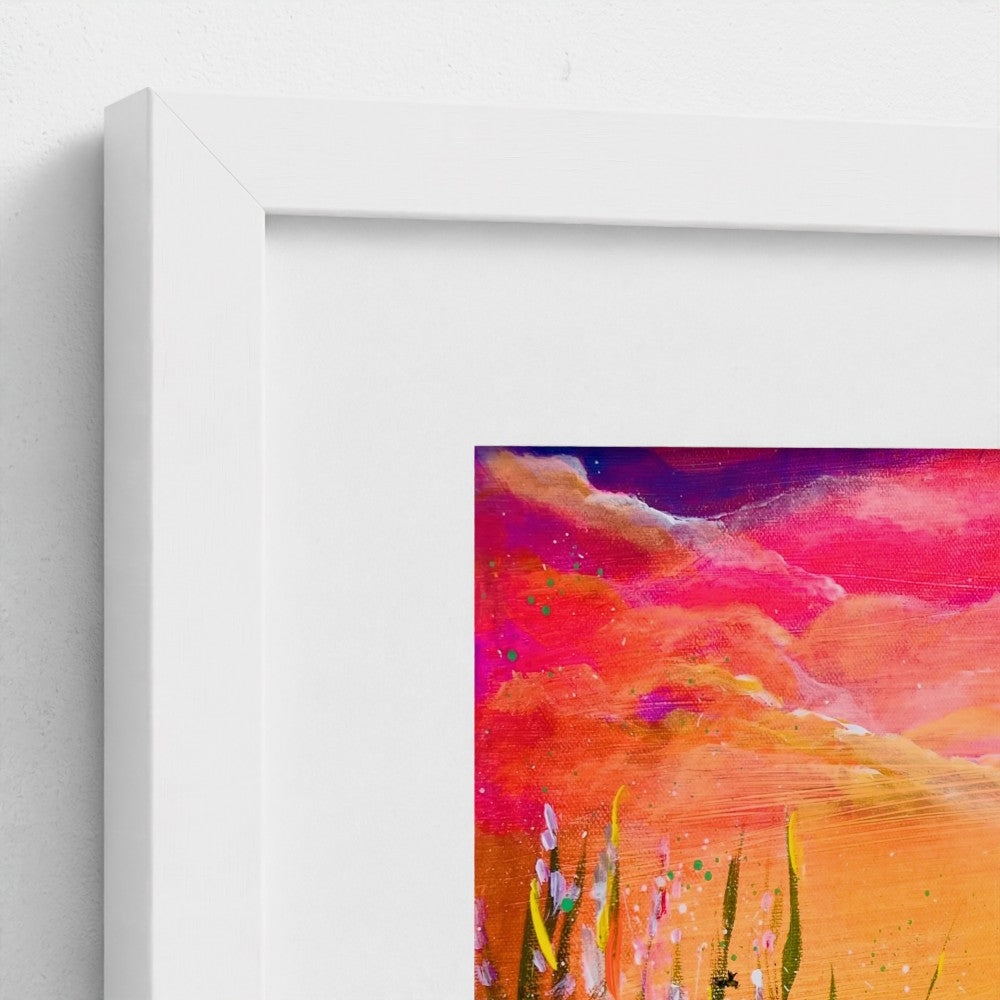 Framed art print with white frame, close view of colorful sky over a field of grass