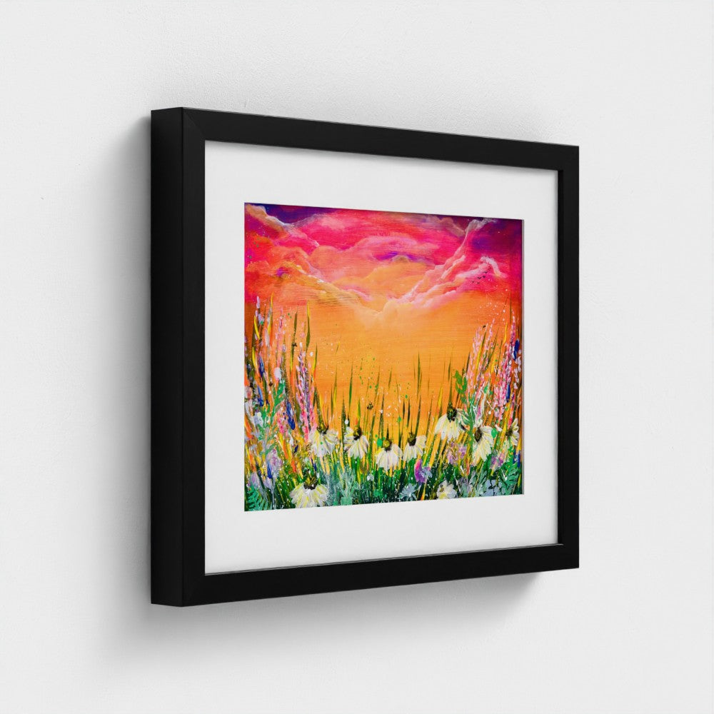 Framed art print with black frame, colorful sky and flower meadow landscape