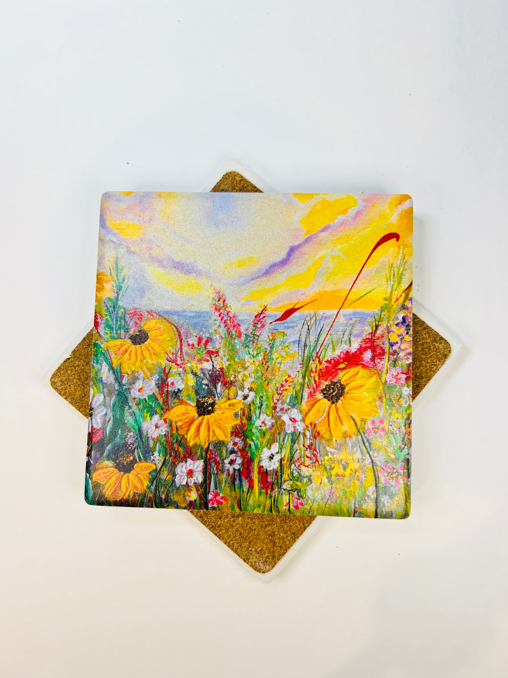Square ceramic coasters stacked; top shows meadow flowers and daisies art.